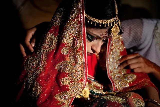Nasoin Akhter, 15, is consoled by a friend on the day of her wedding to a 32-year-old man, August 20, 2015, in Manikganj, Bangladesh. (Photo by Allison Joyce/Getty Images)