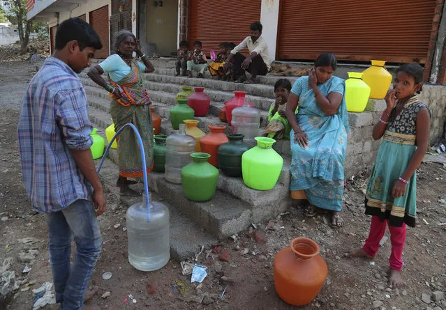 Residents of a poor neighborhood collect potable water from a public tap in Hyderabad, India, Wednesday, March 18, 2020. (Photo by Mahesh Kumar A./AP Photo)