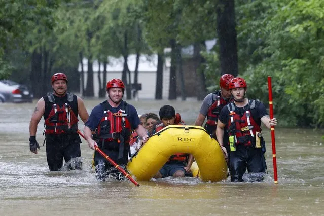 Members of the Balch Springs Fire Department bring a family of four by boat to higher ground after rescuing them from their home along Forest Glen Lane in Balch Springs, Texas, Monday, August 22, 2022. (Photo by Elías Valverde II/The Dallas Morning News via AP Photo)