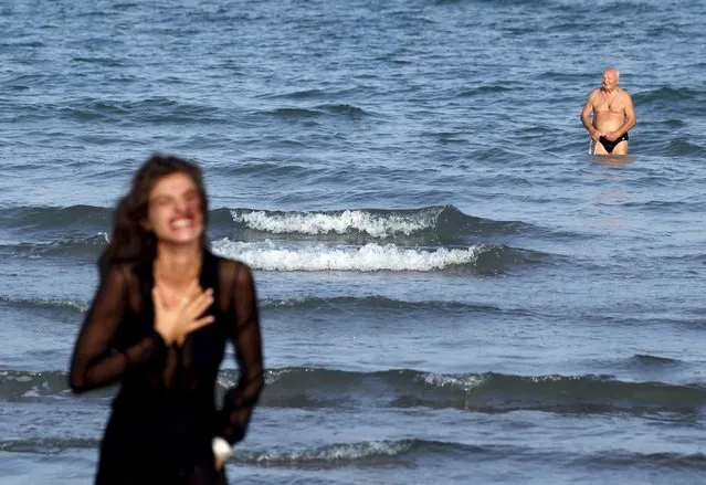 A man looks on from the sea as Italian model and actress Elisa Sednaoui poses for photographers a day before the 72nd Venice Film Festival in Venice, Italy, September 1, 2015. (Photo by Stefano Rellandini/Reuters)