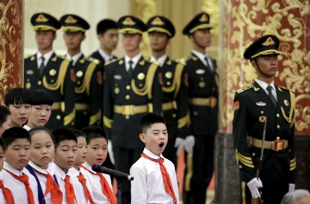 A student yawns in front of soldiers from the honor guards at a medal ceremony marking the 70th anniversary of the Victory of Chinese People's War of Resistance Against Japanese Aggression, for World War Two veterans, at the Great Hall of the People in Beijing, China September 2, 2015. (Photo by Jason Lee/Reuters)