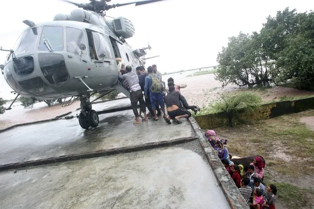 Indian Air Force personnel board flood-affected victims on a MI-17 helicopter during a rescue operation at a flooded area in Hamirpur Kona in Rajouri district, northwest of Jammu September 6, 2014. Authorities declared a disaster alert in the northern region after two days of heavy rain hit villages across the Kashmir valley, causing the worst flooding in two decades. (Photo by Reuters/Indian Ministry of Defence)