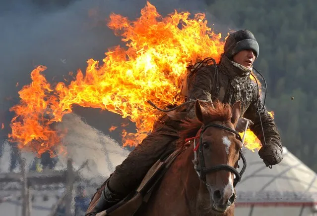 Photo taken on September 10, 2014 shows a Kyrgyz stuntman performing during the first World Nomad Games in the Kyrchin (Semenovskoe) gorge, some 300 km from Bishkek. (Photo by Vyacheslav Oseledko/AFP Photo)