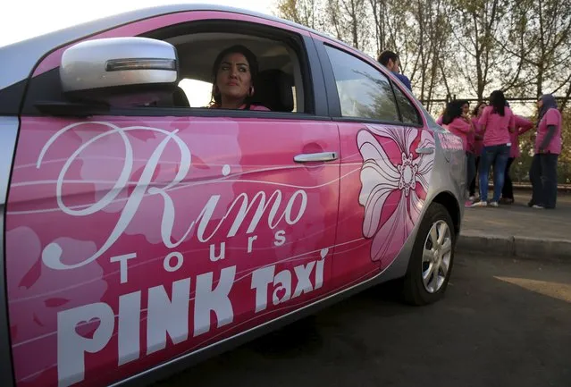Mervat al-Badry, a Pink Taxi driver, sits behind the wheel of her taxi as colleagues chat in a parking lot in Cairo, Egypt, September 6, 2015. (Photo by Amr Abdallah Dalsh/Reuters)