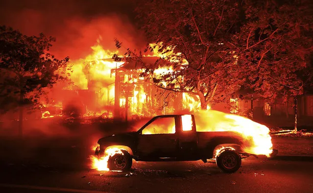 Coffey Park homes burn early Monday October 9, 2017 in Santa Rosa, Calif. More than a dozen wildfires whipped by powerful winds been burning though California wine country. The flames have destroyed at least 1,500 homes and businesses and sent thousands of people fleeing. (Photo mby Kent Porter/The Press Democrat via AP Photo)