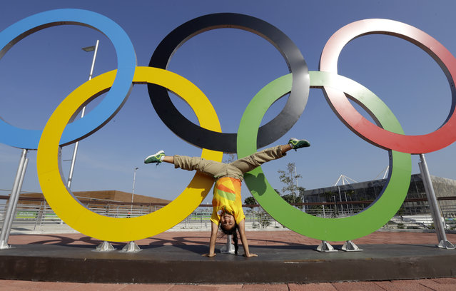 Leidy Romero Alarcon, of Colombia, does a hand stand while posing for a photograph in front of the Olympic Rings at the Olympic Park ahead of the 2016 Summer Olympics in Rio de Janeiro, Brazil, Friday, August 5, 2016. (Photo by Julio Cortez/AP Photo)