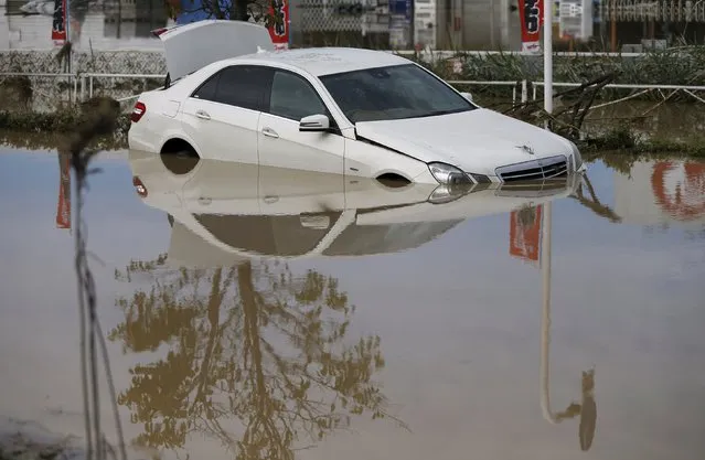 A damaged Mercedes-Benz car is seen at a residential area flooded by the Kinugawa river, caused by typhoon Etau, in Joso, Ibaraki prefecture, Japan, September 11, 2015. (Photo by Issei Kato/Reuters)