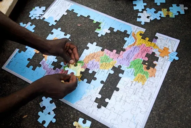 Migrants assemble a puzzle depicting Italy on a map, at a makeshift camp in Via Cupa (Gloomy Street) in downtown Rome, Italy, August 2, 2016. (Photo by Max Rossi/Reuters)
