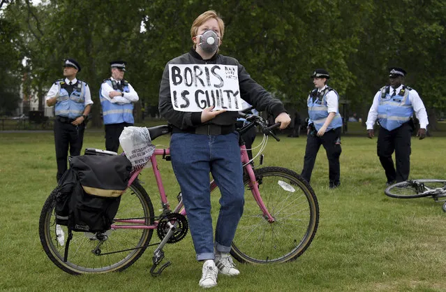 A protestor rests on his bicycle during protests in London, Friday, June 12, 2020 in response to the recent killing of George Floyd by police officers in Minneapolis, USA, that has led to protests in many countries and across the US. (Photo by Alberto Pezzali/AP Photo)