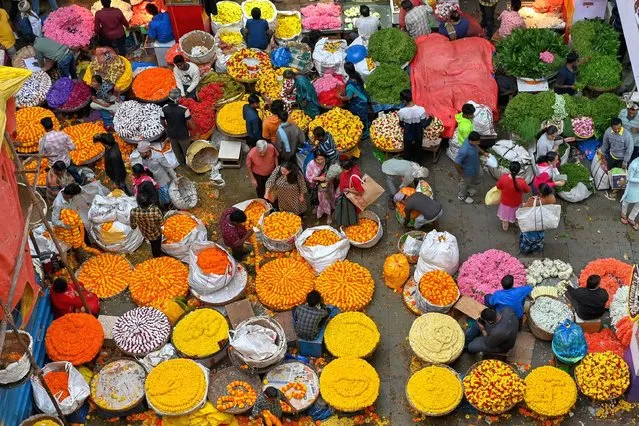 People crowd at a flower market on the eve of Diwali, the Hindu festival of lights, in Bangalore on October 23, 2022. (Photo by Manjunath Kiran/AFP Photo)