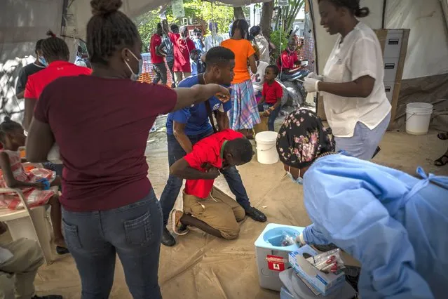 A youth suffering from cholera symptoms is helped upon arrival at a clinic run by Doctors Without Borders in Port-au-Prince, Haiti, Thursday, October 27, 2022. (Photo by Ramon Espinosa/AP Photo)