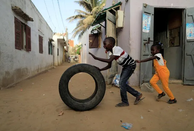 Children play with a tire, amid the outbreak of the coronavirus disease (COVID-19), in Yoff neighbourhood of Dakar, Senegal on June 24, 2020. (Photo by Zohra Bensemra/Reuters)