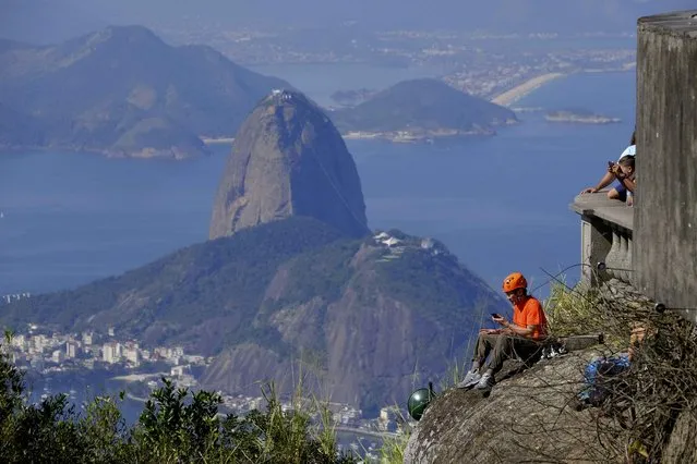 A climber rests on the edge of Corcovado mountain before the start of the Rio 2016 Olympics in Rio de Janeiro, July 24, 2016. (Photo by Paul Robinson/Reuters)