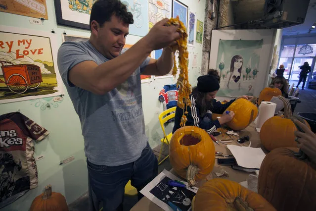 A workshop attendee pulls out innards from his pumpkin at Cotton Candy Machine in Brooklyn, N.Y. on October 18, 2014. (Photo by Siemond Chan/Yahoo Finance)