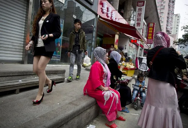 A Han woman walks past Uighur women in Shanghai, in this April 11, 2014 file photo. The custom of women wearing face veils is not a tradition of minority people in China's western area of Xinjiang or in any Muslim country, but is a symbol of extremism and backwardness instead, a senior regional official said on September 24, 2015. (Photo by Aly Song/Reuters)