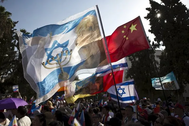 Participants wave their national flags during an annual parade on the Jewish holiday of Sukkot in Jerusalem October 1, 2015. (Photo by Ronen Zvulun/Reuters)
