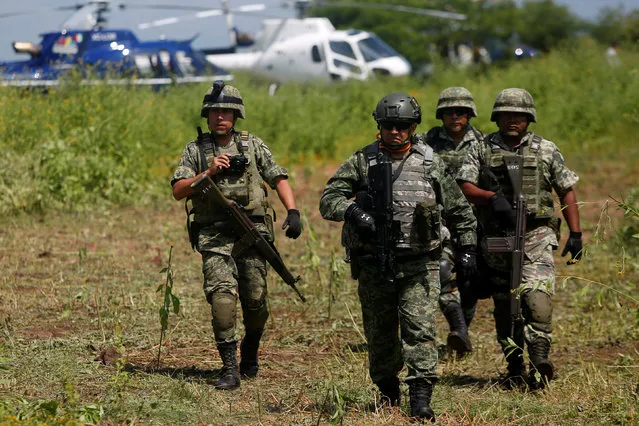 Soldiers guard the crash site where a police helicopter was shot down by suspected gang members during clashes with police,in La Huacana-Michoacan, Mexico, September 7, 2016. (Photo by Alan Ortega/Reuters)