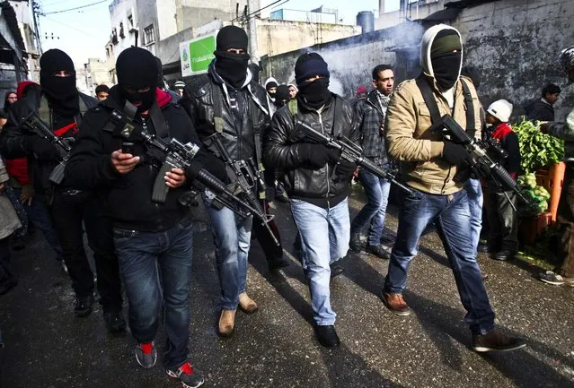 A group loyal to Palestinian leader Mahmoud Abbas' Fatah movement march in the Balata refugee camp in the West Bank, January 10, 2013. The men were protesting a recent campaign by Abbas to disarm renegade gunmen. (Photo by Nasser Ishtayeh/Assoicated Press)