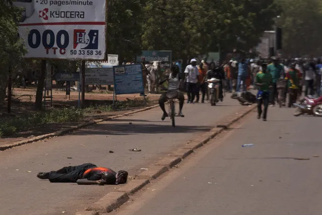 A man lies injured from bullet wounds fired by Burkinabe soldiers in Ouagadougou, capital of Burkina Faso, October 30, 2014. (Photo by Joe Penney/Reuters)