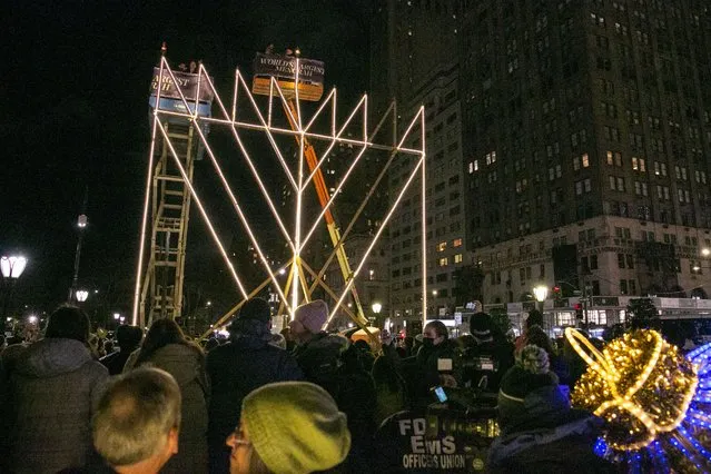 The crowd watches as the world's largest menorah is lit for the first time this Hanukkah season at Fifth Avenue and 59th Street, in New York, New York, USA, 18 December 2022. The 36-foot menorah will be lit for eight nights beginning Sunday at sundown to celebrate the Jewish holiday of Hanukkah. (Photo by Sarah Yenesel/EPA/EFE)