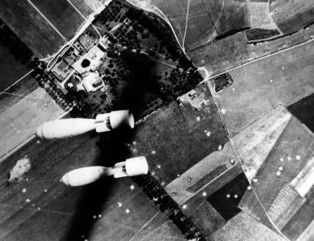 Twin missiles of destruction let loose by the Royal Air Force during a successful raid on Abbeville, France, aerodrome on July 20, 1940, held by Germans. Numerous bomb craters may be seen over the area. (Photo by AP Photo)