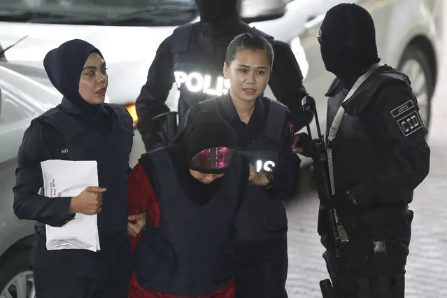 Indonesian Siti Aisyah, second left, is escorted by police as she arrives for court hearing at Shah Alam court house in Shah Alam, Malaysia, Monday, January 22, 2018. Malaysia's high-profile trial of Siti Aisyah and Vietnam's Doan Thi Huong accused of killing Kim Jong Nam, the estranged half brother of North Korea's leader resumes Monday after a seven-week recess, with defense lawyers saying their efforts have been stymied by missing links. (Photo by Sadiq Asyraf/AP Photo)