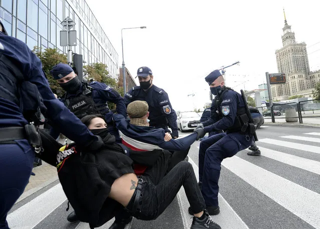 Polish police carry protesting environmentalists to the side to clear passage down one of Warsaw's main streets in Warsaw, Poland, Monday, September 7, 2020. The Polish chapter of the international environmental group Extinction Rebellion blocked the street to spur the government into better protection of the environment, in a second such action in two days, in Warsaw. (Photo by Czarek Sokolowski/AP Photo)