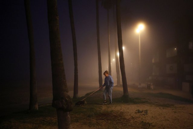 A woman walks a dog as fog shrouds Venice Beach In Los Angeles, California, U.S., January 2, 2025. (Photo by Daniel Cole/Reuters)
