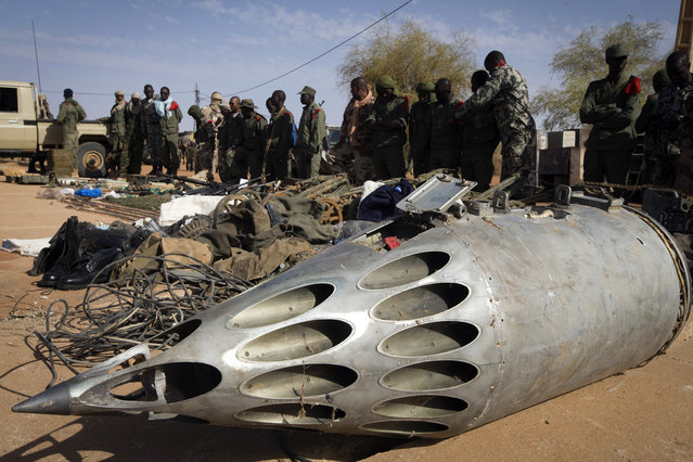 Soldiers stand in front of a rocket pod launcher and weapons seized from Islamist fighters, exhibited by the Malian army in the center of Gao, on February 24, 2013. (Photo by Joel Saget/AFP Photo/The Atlantic)
