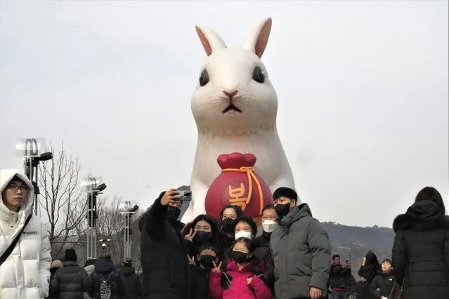 A family member takes a selfie in front of a giant rabbit installation to celebrate the Year of the Rabbit for 2023 in the Chinese zodiac at Gwanghwamun Square in Seoul, South Korea, Sunday, January 22, 2023. (Photo by Ahn Young-joon/AP Photo)