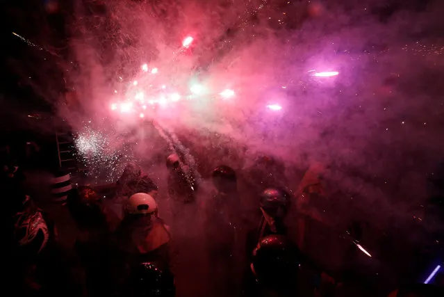 Participators wearing motorcycle helmets get sprayed with firecrackers, during the “Beehive Firecrackers” festival at the Yanshui district in Tainan, Taiwan on March 1, 2018. (Photo by Tyrone Siu/Reuters)