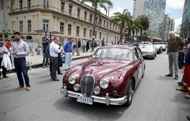People observe a 1966 Jaguar during the 25th edition of the "1000 millas sport e historicos" (1000 miles sports and classic) race in Montevideo, October 28, 2015. (Photo by Andres Stapff/Reuters)