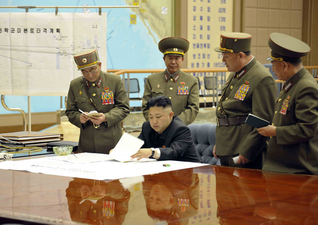 A picture released by the North Korean Central News Agency (KCNA) on 29 March 2013 shows North Korean leader Kim Jong-un (sitting) convening an urgent operation meeting at 0:30 am on 29 March 2013 at an undisclosed location, in which he ordered strategic rocket forces to be on standby to strike US and South Korean targets at any time. Kim's order followed two US stealth bombers' first-ever drill over the Korean Peninsula the previous day. The North berated the drill as US hostility against it. (Photo by EPA/KCNA)