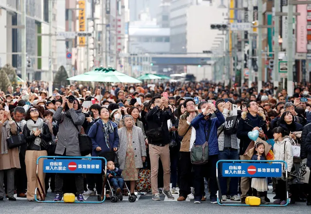 People look at a clock tower during a moment of silence at 2:46 p.m. (0546 GMT), the time when the magnitude 9.0 earthquake struck off Japan's coast in 2011, at a holiday promenade at Ginza shopping district in Tokyo, Japan, March 11, 2018, to mark the seven-year anniversary of the earthquake and tsunami that killed thousands and set off a nuclear crisis. (Photo by Issei Kato/Reuters)