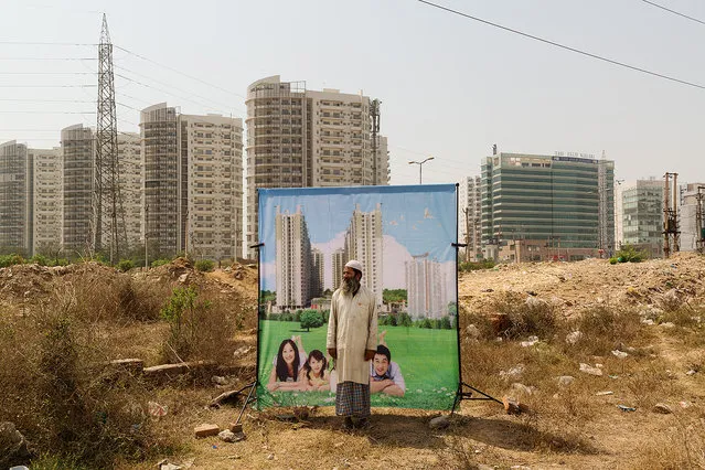 Inspired by traditional Indian travelling photography studios, Arthur Crestani photographed the inhabitants of Gurgaon, a city built almost entirely by private companies. Arthur Crestani’s “Bad City Dreams” contrasts the glossy ideal sold by developers with urban reality. Here: AVJ Platinum #1: “Enhancing Lifestyles ...”. (Photo by Arthur Crestani/The Guardian)