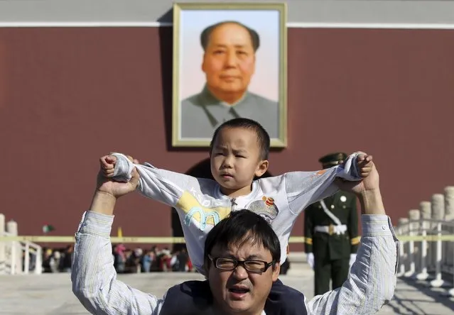 A boy sits on his father's shoulders as they pose for a photograph in front of the giant portrait of late Chinese chairman Mao Zedong on the Tiananmen Gate, in Beijing, China, October 2, 2011. China will ease family planning restrictions to allow all couples to have two children after decades of the strict one-child policy, the ruling Communist Party said on October 29, 2015, a move aimed at alleviating demographic strains on the economy. (Photo by Reuters/Stringer)