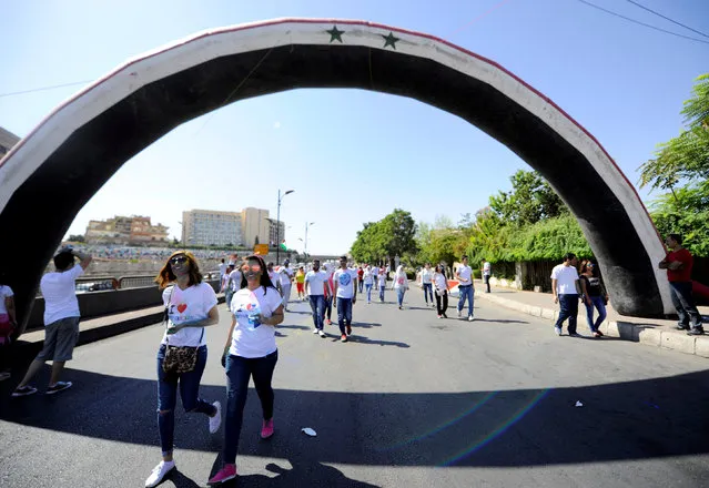 Participants walk towards Umayyad Square during “I Love Damascus” marathon in Damascus, Syria October 7, 2016. (Photo by Omar Sanadiki/Reuters)