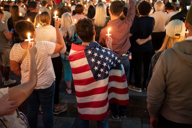 An attendee wears a U.S. flag during a candlelight vigil for Turning Point USA Founder Charlie Kirk on September 10, 2025 in Seattle, Washington. Kirk was shot dead while speaking at Utah Valley University earlier in the day. (Photo by David Ryder/Getty Images)