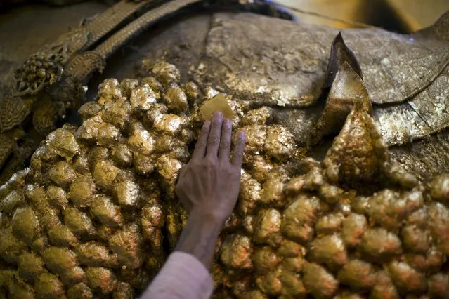 A man touches a golden Buddha statue inside Mahamuni Buddhist temple in Mandalay October 6, 2015. (Photo by Jorge Silva/Reuters)