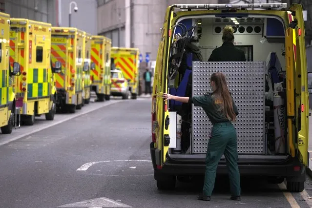 A paramedic opens the doors of an ambulance to take a patient into the Royal London Hospital in the Whitechapel area of east London, January 6, 2022. The omicron variant is exposing weaknesses at the heart of Europe's public health system. In France and Britain, a sharp rise in coronavirus hospitalizations coupled with staff falling sick has led to a shortage of beds. (Photo by Matt Dunham/AP Photo/File)