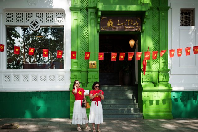 People wear Viatnam's national flag T shirt along Hoan Kiem lake of the old quarter in Hanoi, Vietnam, Sunday, August 31, 2025 as the country prepares for the 80th National Day celebrations. (Photo by Vincent Thian/AP Photo)