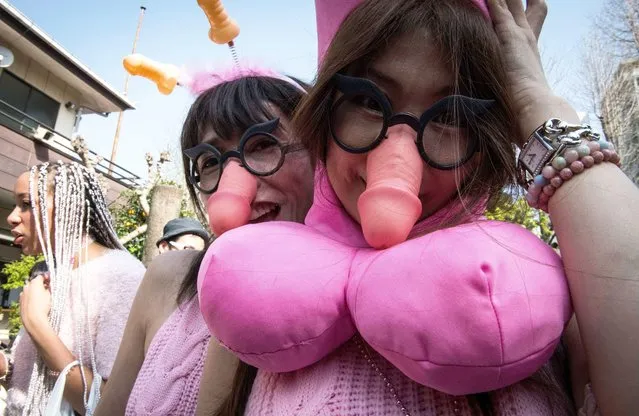 Festival goers pose for photos with their phallic shaped souvenirs during the annual Kanamara Festival at Kanayama Shrine in Kawasaki, Japan on April 1, 2018. The fertility festival, originated from prostitutes who wished to pray for good business and protection from sexually transmitted diseases, nowadays, festival goers celebrates for fertility, relationships and for safe s*x practices. Attracting tens of thousands of festival goers including tourists, people can buy pen*s shape candies, key chains, trinkets, pens, chocolates and even toy glasses with a plastic pen*s nose. (Photo by Aflo/Rex Features/Shutterstock)