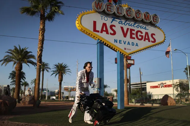 Elvis Presley impersonator, Eddie Powers, walks past a Welcome to Las Vegas sign as Democratic presidential candidate Hillary Clinton and Republican presidential candidate Donald Trump prepare for their final presidential debate at the Thomas & Mack Center in Las Vegas on October 17, 2016 in Las Vegas, Nevada. Clinton and Trump are scheduled to participate in the final debate on October 19. (Photo by Joe Raedle/Getty Images)