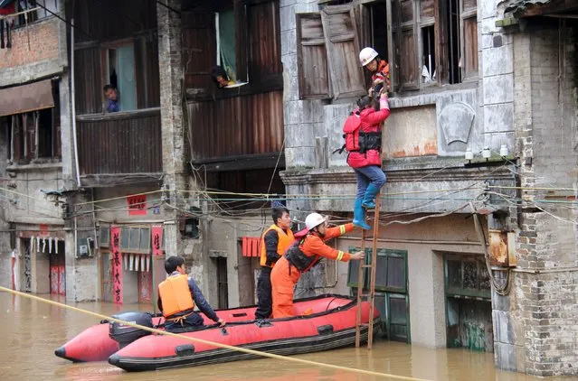 Rescue workers try to remove a woman from a flooded area after heavy rainfall in Hezhou, Guangxi Zhuang Autonomous Region, China, November 13, 2015. (Photo by Reuters/Stringer)