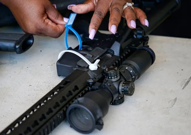 A City of Miami Police officer tags an AR-15 rifle during a City of Miami gun buy-back event in Miami, Florida on March 17, 2018. The city bought over 100 guns, the best ever from a buy-back event. Up to $250 in gift cards was offered in the first of a series of buy-backs planned by Miami. (Photo by Rhona Wise/AFP Photo)