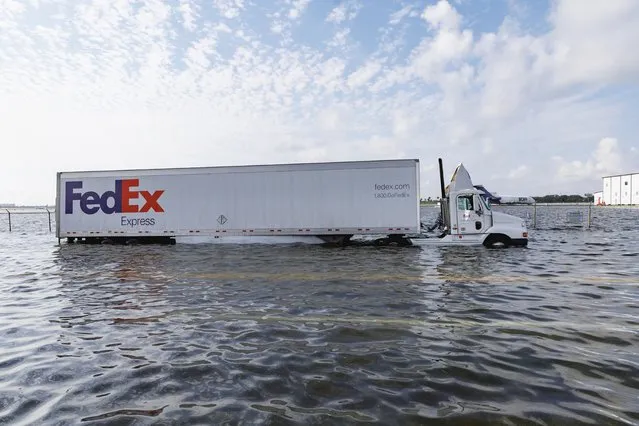 A Fedex truck submerged in flooded street caused by heavy rain on West Perimeter Road in Fort Lauderdale on Thursday, April 13, 2023. (Photo by David Santiago/Miami Herald via AP Photo)