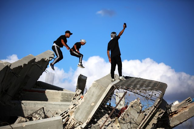 Young Palestinian athletes perform parkour moves among the ruins of destroyed buildings in the al-Mughraqa area, following the ceasefire in Gaza City, Gaza, on October 13, 2025. The athletes use their sport to draw attention to the destruction caused by Israeli attacks, showcasing acrobatic skills amid the rubble. (Photo by Hassan Jedi/Anadolu via Getty Images)