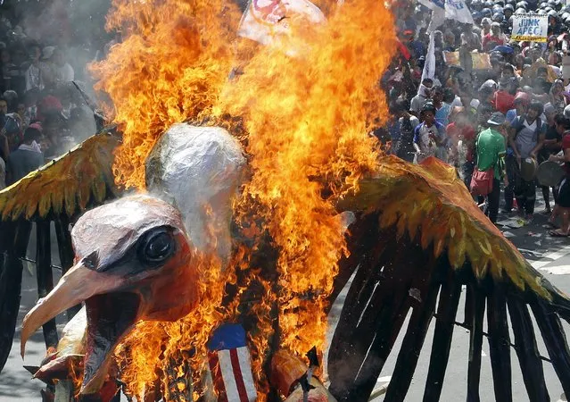 Protesters burn an effigy during a rally near the venue of the Asia-Pacific Economic Cooperation (APEC) summit, in Manila November 19, 2015. (Photo by Cheryl Gagalac/Reuters)