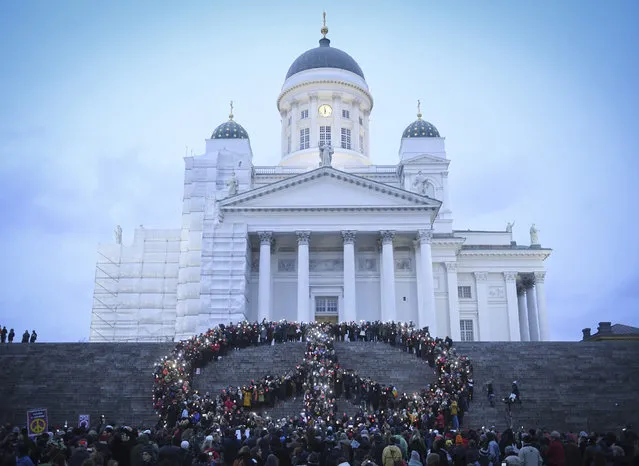 People gather to form a peace sign in front of the Helsinki Cathedral as they rally during a Save Syria – peace march and demonstration in Helsinki Finland, 24 October 2016. (Photo by Kimmo Brandt/EPA)