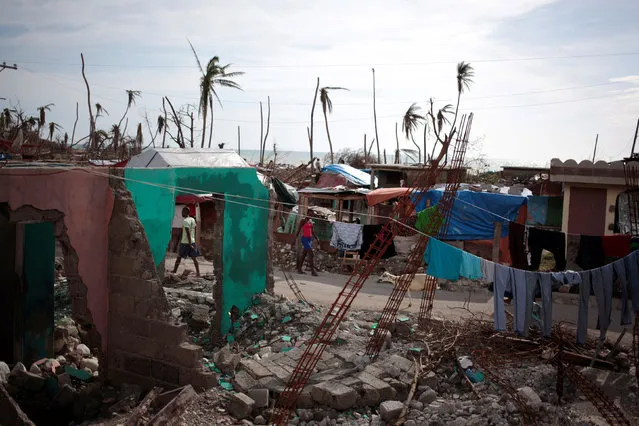 People walk in the street next to houses destroyed by Hurricane Matthew in Damassins, Haiti, October 22, 2016. REUTERS/Andres Martinez Casares